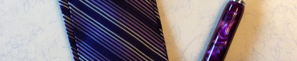 Striped tie case with purple pen nearby.