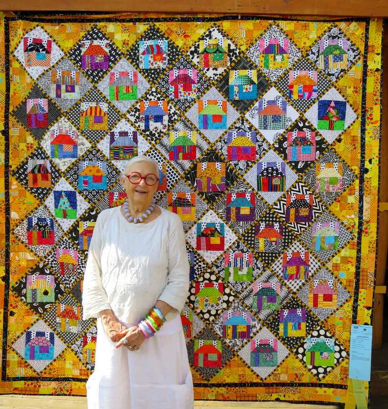 Freddy Moran of Orinda CA in front of her quilt Houses on Point (80 square)