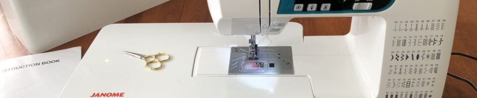 Janome sewing machine on a wooden table.