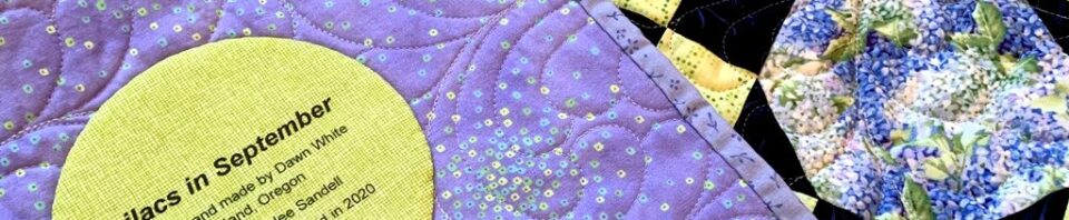 Colorful quilt with lilac and floral patterns.