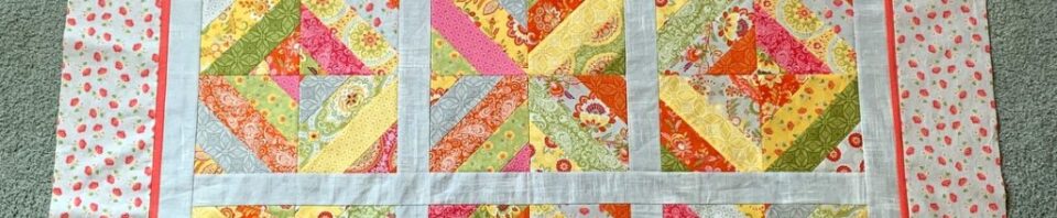 Colorful quilt with geometric patterns and floral border.