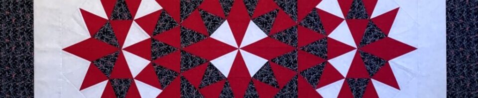 Red and black star-patterned quilt design.