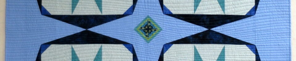 Colorful quilt with star patterns on blue.